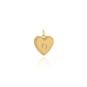 Macro shot of 18K gold plated heart pendant with engraved letter O and grooved edges