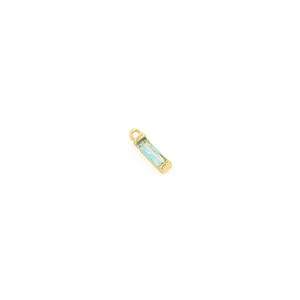 Macro detail of a 18K gold-plated rectangular pendant with a light blue baguette-cut gemstone