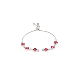 Detail of adjustable silver bracelet featuring seven round red gemstones in bezel settings