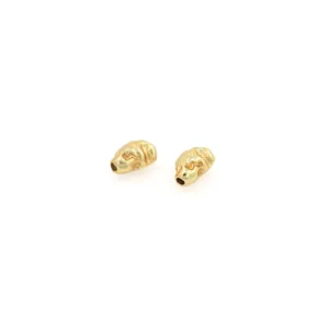 Close-up of irregular 18K gold plated beads with matte hammered texture and hole for DIY