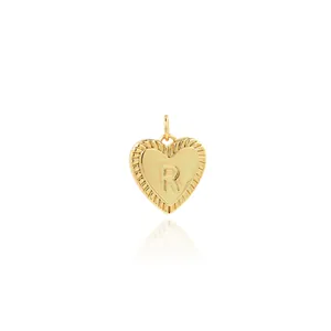 Detailed view of an 18K gold plated heart pendant with embossed letter R and radiating ridges