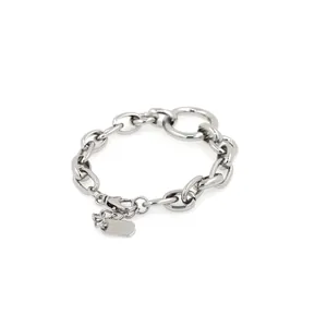 Detailed macro view of chunky silver chain link bracelet with Good Luck engraved tag