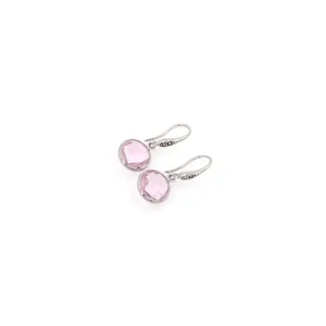 Détail macro de boucles d'oreilles créoles argentées avec zircone rose ronde brillante