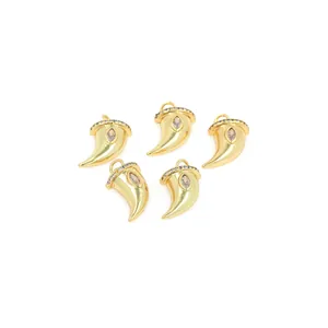 Detail of five 18K gold plated horn pendants with zircon inlay for jewelry making