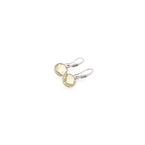 Vue macro des boucles d'oreilles pendantes plaquées or 18K avec zircon jaune et pavé