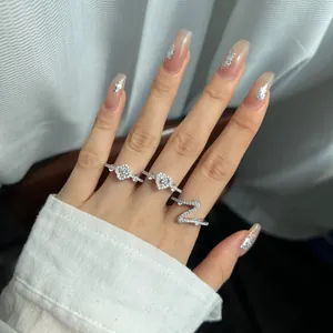 Detail view of S925 sterling silver rings with flower and heart shapes worn on fingers