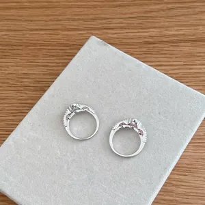Macro view of two S925 sterling silver rings with white and pink zircon stones