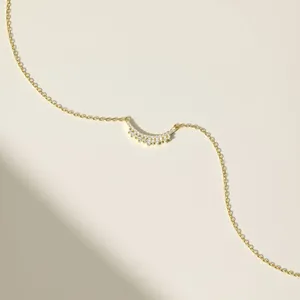 Detail of s925 silver crescent moon necklace with sparkling cubic zirconia on gold chain