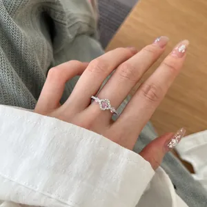 Close-up of S925 silver ring featuring pink flower cluster stones on a model's finger