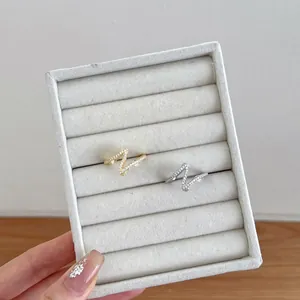 Macro shot of silver and gold Z-shaped rings with micro-pave zircons in a velvet box