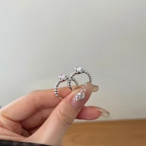Detail of S925 silver rings with pink and clear oval zircon stones on beaded bands