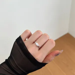 Close-up of a marquise-cut zircon silver ring worn with stylish black mesh and sequins