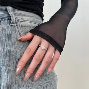 Detailed view of silver S925 heart ring with zircon stone worn against denim pocket