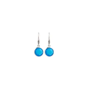 Détail de boucles d'oreilles argentées avec cristal bleu rond et accents en micro-pavé