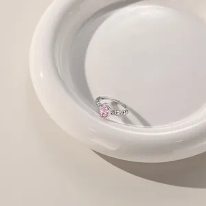 Detail of s925 silver ring with oval pink zircon in prong setting on ceramic plate