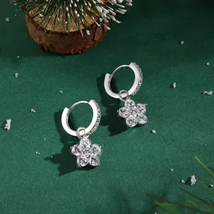 Macro shot of silver flower earrings with zircon petals on festive winter background