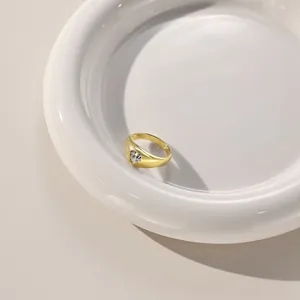 Top view of a gold-plated thick band ring featuring a heart-shaped inlaid zircon on ceramic