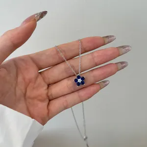 Detailansicht einer S925 Silber Blumenkette mit blauen Zirkonia Steinen in der Hand gehalten