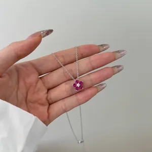 Nahaufnahme der silbernen Blumenkette mit rosaroten Zirkonia auf der Hand