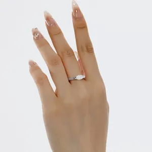Detailed close-up of a marquise cut stone ring on a finger with a minimalist silver band
