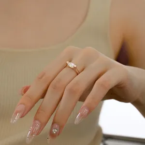 Close-up of a marquise cut zircon ring in gold finish worn on a finger