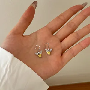 S925 sterling silver bee drop earrings with yellow heart zircon held in hand