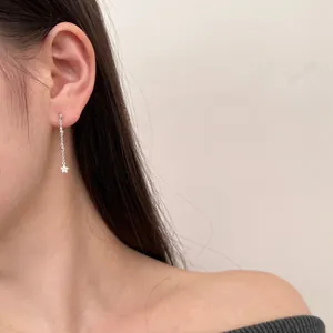 Close-up of elegant S925 sterling silver star fringe earrings worn by a model