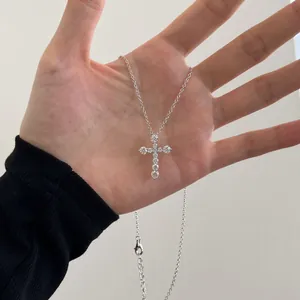 Details der s925 Silberkreuzkette mit funkelnden Zirkonia-Steinen, in der Hand gehalten