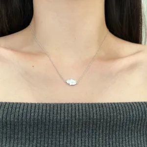 Detail of s925 silver Hamsa Hand necklace with zircon on a person's neckline