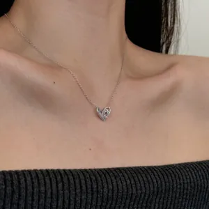 Gros plan d'un collier cœur en argent 925 avec zircon sur un cou de femme