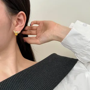Close-up of elegant bee earring featuring yellow pear-cut stone and zircon inlay