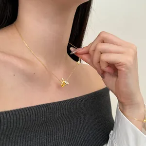 Close-up of gold bee jewelry set with sparkling zircons on model neck and wrist