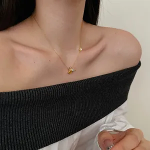 Close-up of golden bee necklace with yellow gemstone and pavé diamonds on a model neck