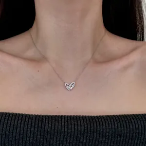 Élégant collier en argent 925 avec cœurs entrelacés et zircons porté par un mannequin