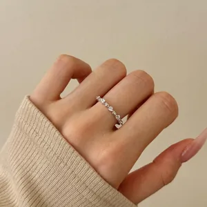 Macro view of dainty S925 sterling silver band ring with pave-set zircon stones