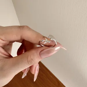 Detail of adjustable S925 silver airplane and cloud ring worn on a model's hand