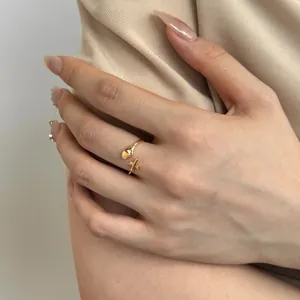 Detailed view of gold airplane and heart motifs on a polished adjustable sterling silver ring