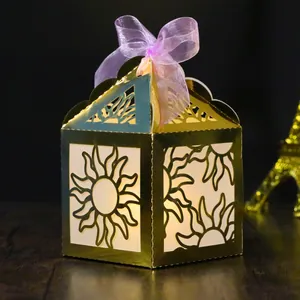 Golden laser-cut hexagon party gift box with sun pattern and purple ribbon bow