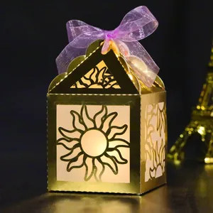 Detail of gold hollow laser-cut gift box with purple ribbon and warm interior glow