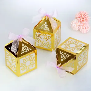 Three gold laser-cut hollow lanterns with sun patterns and pink organza ribbons