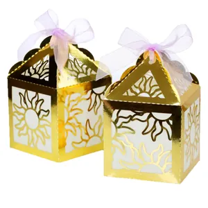 Golden laser-cut hollow lanterns with purple organza ribbons for festive party decor