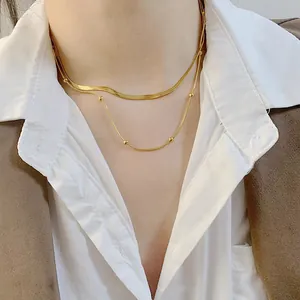 Elegant gold-tone double-layer necklace with flat snake chain and delicate gold beads