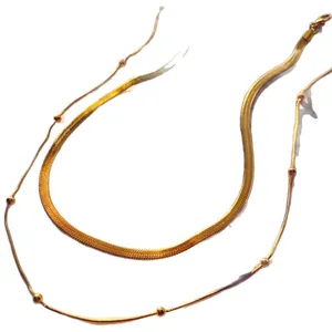 Elegant gold double-layered necklace featuring flat herringbone and beaded chains