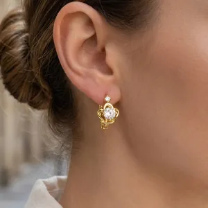 Close-up of golden crown leverback earring with sparkling round zircon stone inlay