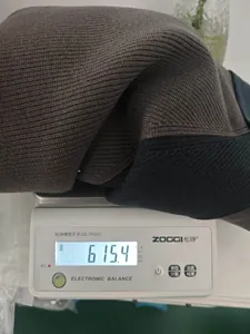Gedetailleerde gewichtsmeting van 615,4g op een weegschaal voor dit dikke gebreide vest