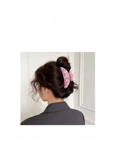 Rückansicht eines Models mit großer Haarspange mit rosa Marmormuster in einer Hochsteckfrisur