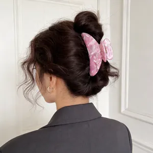 Haarklammer aus Acetat in Rosa Marmoroptik an einer eleganten Hochsteckfrisur für Damen