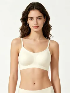 Front view of seamless vest bra with thin straps in cream white on female model
