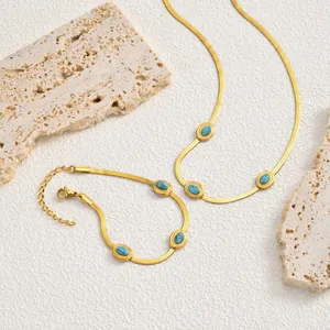 Dettaglio del set collana e bracciale a catena piatta dorata con pietre turchesi