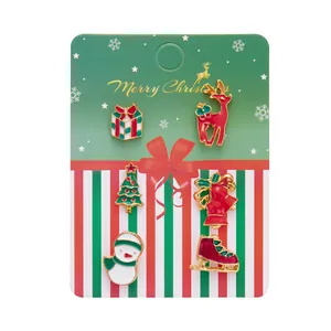 Close-up of 6 Christmas enamel pins including reindeer, snowman and tree on a card